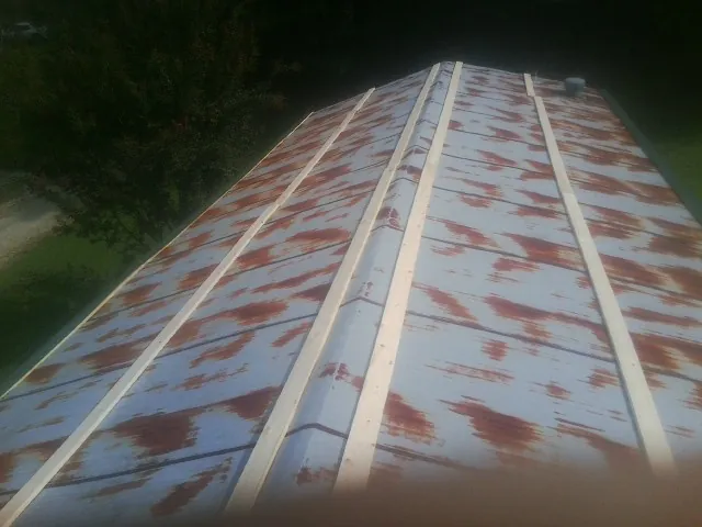 Rusted metal roof panels with new wood purlins before replacement — Storm Damage Roof Repair in Westland by Roofing Brothers