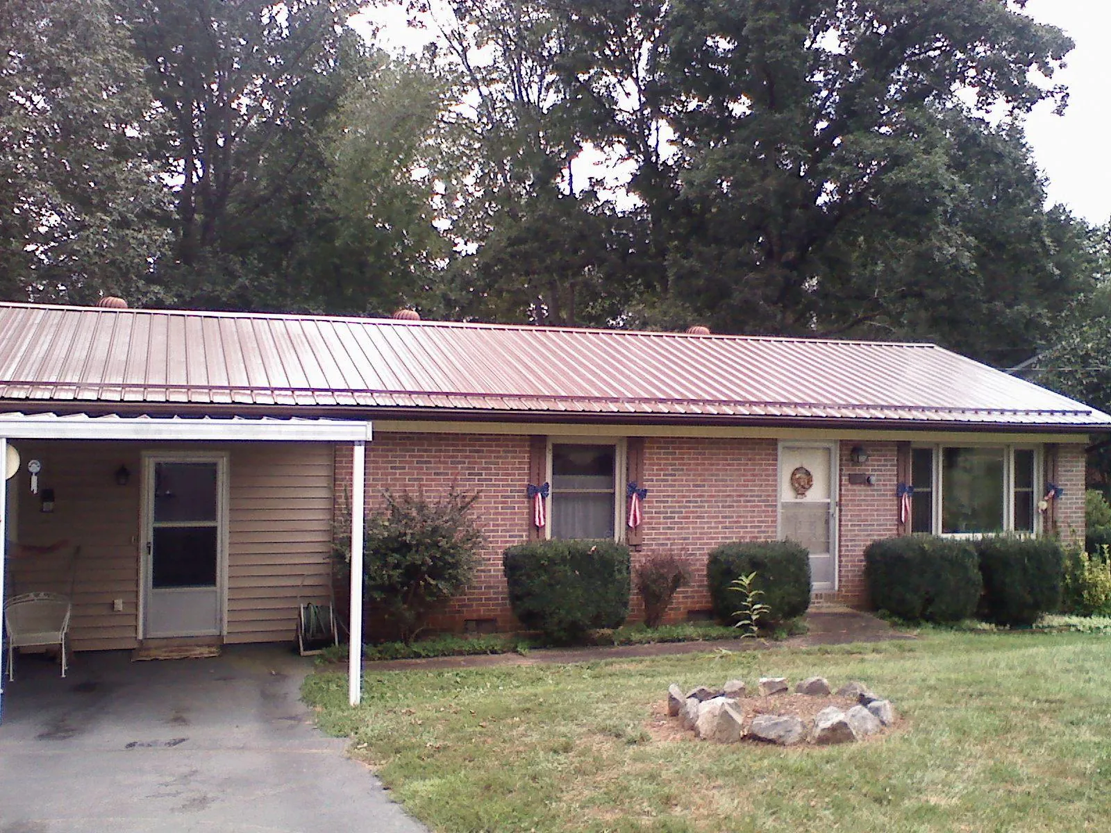 Bronze metal roof and carport on a brick ranch home — Roof Repair work by our crew in Westland